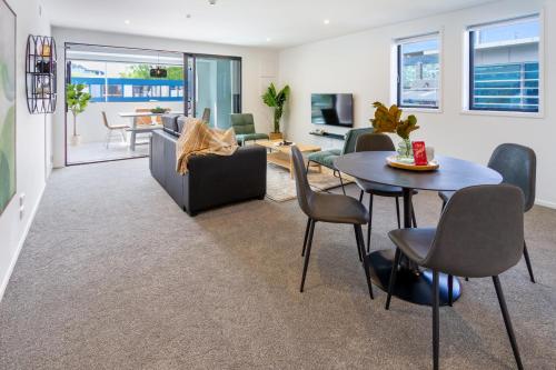 a living room with a couch and a table and chairs at CBD Gem: Walk to everything, 3 bedroom 2 bath in Christchurch