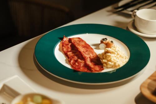 a plate of food with meat and rice on a table at Chill hill cottage in Taiping