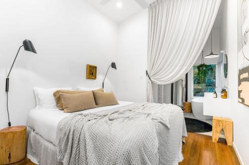 Habitación blanca con cama y ventana en A Perfect Stay - The Chalet, en Byron Bay