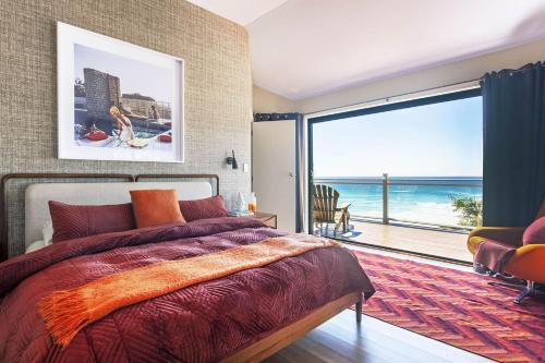 a bedroom with a bed and a view of the ocean at A Perfect Stay - The Palms at Byron in Byron Bay
