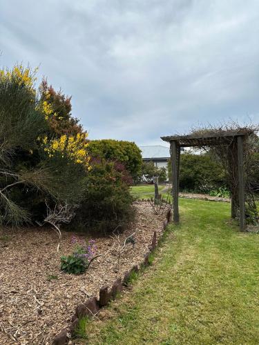 a garden with a wooden pergola and some plants at Two Twenty Two Farm Stay in Grassy