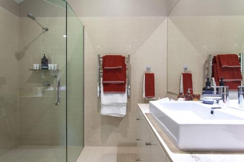 a bathroom with a sink and a glass shower at A Perfect Stay - The Palms at Byron in Byron Bay