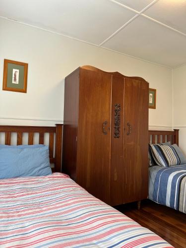 Grassy的住宿－Two Twenty Two Farm Stay，一间卧室设有两张床和木制橱柜