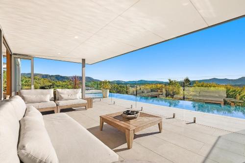 a living room with a couch and a table at The Springs - architect-designed home with pool in Mullumbimby
