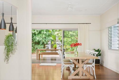 a dining room with a wooden table and chairs at The White Rabbit - with studio & covered deck in Byron Bay