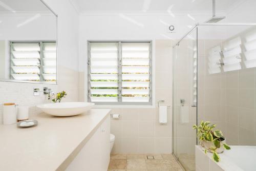 y baño blanco con lavabo y ducha. en A Perfect Stay - The White Rabbit, en Byron Bay