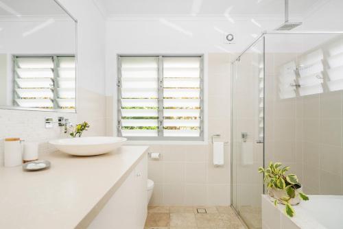 a white bathroom with a sink and a shower at A Perfect Stay - The White Rabbit in Byron Bay