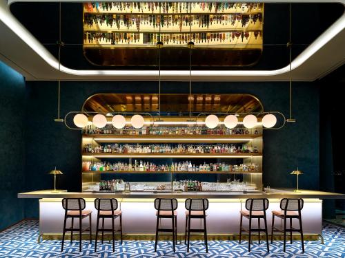 a bar with stools and a shelf of liquor bottles at Parnas Hotel Jeju in Seogwipo