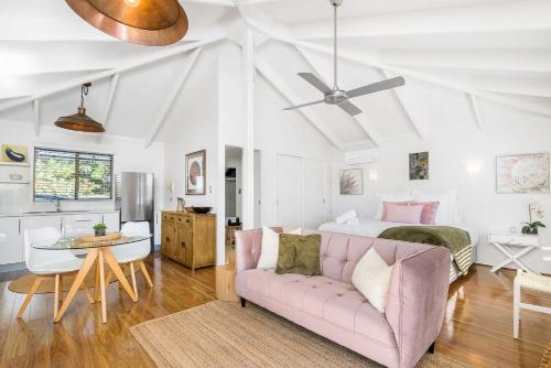 a living room with a pink couch and a bed at A Perfect Stay - Twin Tallows in Bangalow