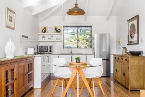 a kitchen with a table and chairs and a refrigerator at A Perfect Stay - Twin Tallows in Bangalow