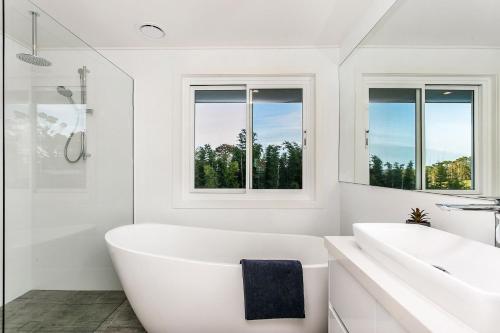 a white bathroom with a tub and two sinks at A Perfect Stay - Villa St Helena in Byron Bay