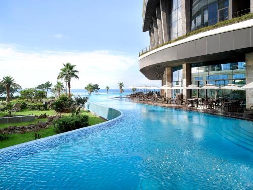 uma piscina em frente a um edifício em Parnas Hotel Jeju em Seogwipo