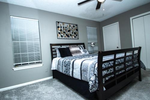 een slaapkamer met een bed en een plafondventilator bij ZEN'S Retreat in North Little Rock