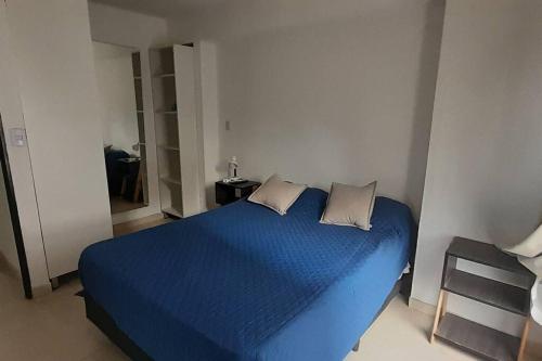 a blue bed with two pillows in a bedroom at Departamento acogedor en San Miguel de Tucumán in San Miguel de Tucumán