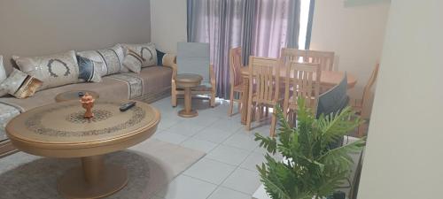 ein Wohnzimmer mit einem Sofa, einem Tisch und Stühlen in der Unterkunft أكادير in Zemmour Touirza