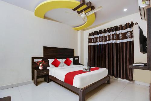 a bedroom with a bed and a ceiling fan at OYO Flagship Hmr Hotel Near Iskcon Temple Bangalore in Bangalore