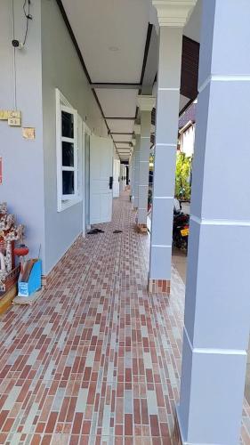 an empty hallway of a building with a brick floor at CS Apartment in Vientiane