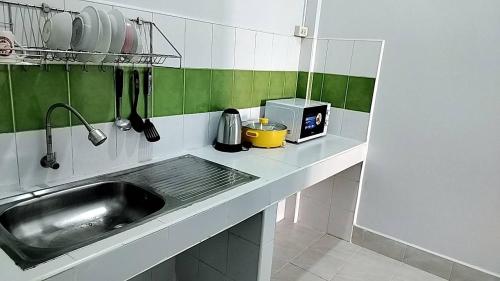 a kitchen counter with a sink and a microwave at CS Apartment in Vientiane
