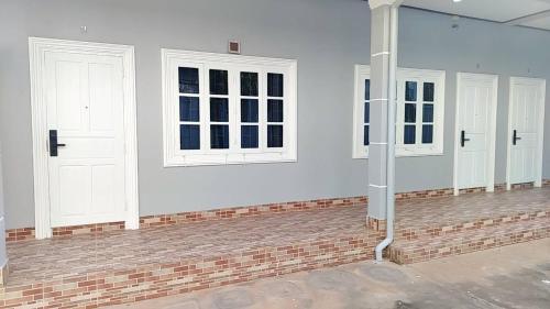 a room with three white doors and a brick floor at CS Apartment in Vientiane