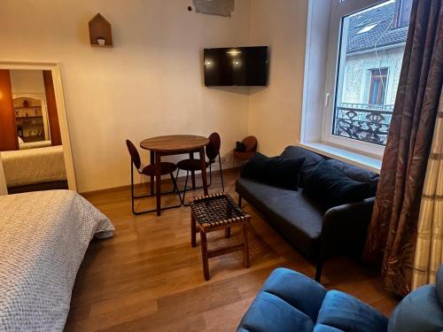 a living room with a couch and a table at MRTN APARTMENTS Studio & Suites - Aix-les-Bains, hypercentre in Aix-les-Bains