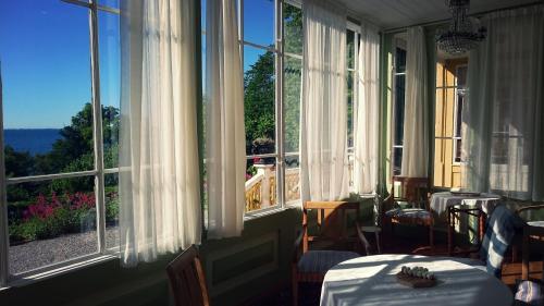 a room with two tables and windows with a view at Fridhems Pensionat in Visby
