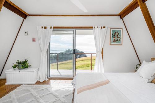 een slaapkamer met een bed en een groot raam bij A Perfect Stay - A Frame in Scotts Head