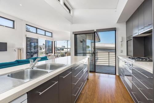 a kitchen with a sink and a large window at A Perfect Stay - Sandy Feet in Lennox Head