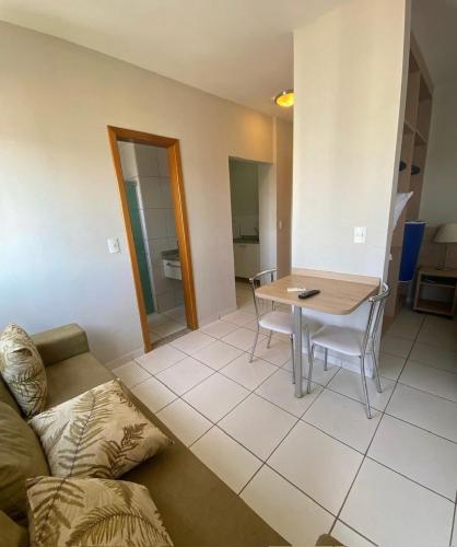 a living room with a table and a couch at Flat Caldas Novas - Golden Dolphin Express in Caldas Novas
