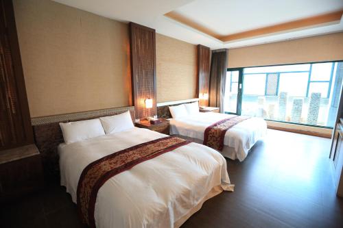 a hotel room with two beds and a large window at Moon Area Motel in Douliu