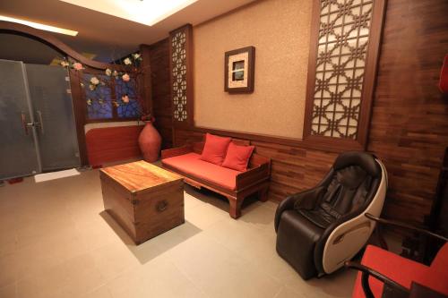 a living room with a couch and a chair at Moon Area Motel in Douliu