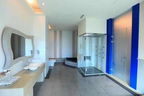 a bathroom with a glass shower and a sink at Moon Area Motel in Douliu