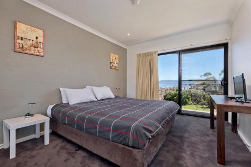 a bedroom with a bed and a large window at Stockyards 3 - Jindabyne Luxury Townhouse in Jindabyne