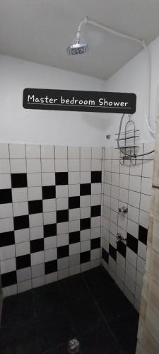 a bathroom with a black and white tiled wall at Chands Apartment in Lautoka