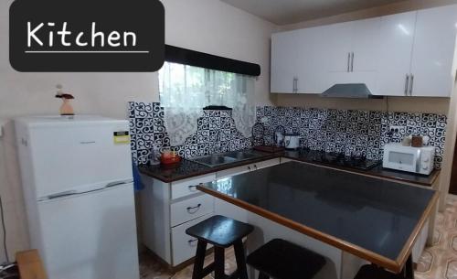 a kitchen with a white refrigerator and a sink at Chands Apartment in Lautoka