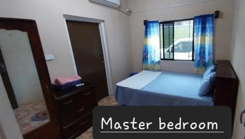 a bedroom with a bed and a mirror and a window at Chands Apartment in Lautoka