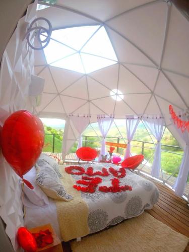 Una cama en una tienda con rosas rojas. en Glamping Villa Luces, en Tocotá