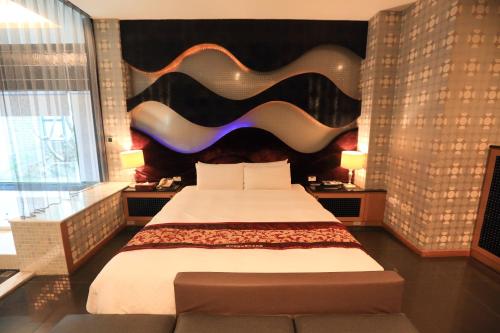 a bedroom with a large bed with a large headboard at Moon Area Motel in Douliu