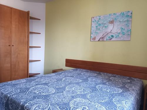 1 dormitorio con 1 cama y una pintura en la pared en Ap aconchegante Floripa, en Florianópolis