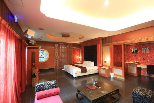 a bedroom with a bed and a table in a room at Moon Area Motel in Douliu