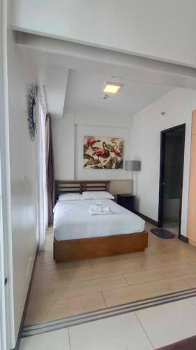 a bedroom with a bed and a painting on the wall at The Mactan Newtown in Punta Engaño