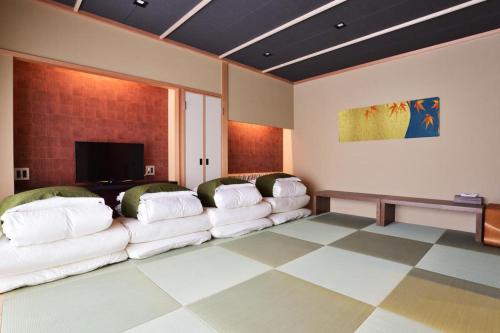 a living room with white couches and a flat screen tv at Suzuran Tengachaya in Osaka
