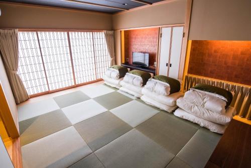 ein Wohnzimmer mit weißen Sofas und einem karierten Boden in der Unterkunft Ryokan Suzuran Tengachaya in Osaka