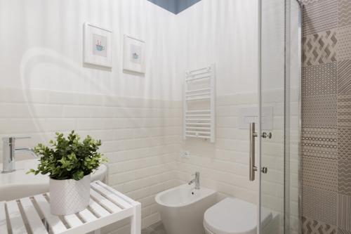 La salle de bains blanche est pourvue de toilettes et d'un lavabo. dans l'établissement Trieste Chic Studio: Historic Elegance, à Trieste