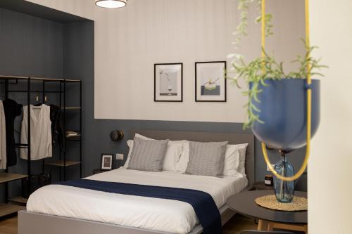 - une chambre avec un lit et un vase bleu orné d'une plante dans l'établissement Trieste Chic Studio: Historic Elegance, à Trieste