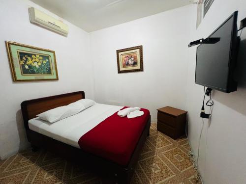 a bedroom with a bed and a flat screen tv at Hotel Barroco in San José