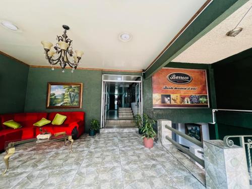 - un salon avec un canapé rouge et un lustre dans l'établissement Hotel Barroco, à San José