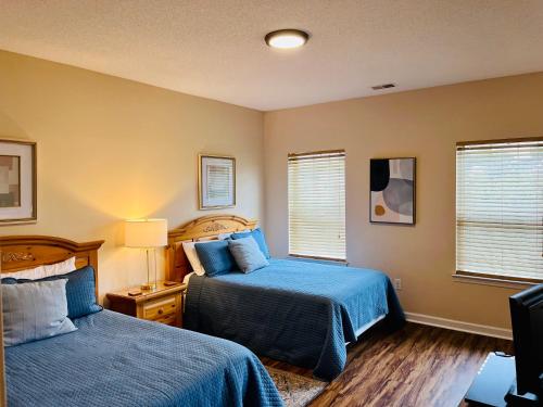 a bedroom with two beds and two windows at Two-Bedroom Vacation Condo in Myrtle Beach