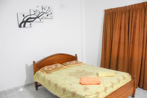 1 dormitorio con 1 cama con cabecero de madera en Maharagama Shehan Hotel en Maharagama