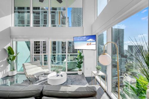 a living room with a couch and a tv at Iconic 2 BR LOFT Brickell-Stunning views in Miami