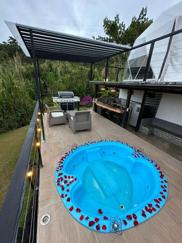 una piscina en una terraza con una casa en Glamping Villa Luces, en Tocotá